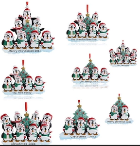 Detailed view of resin penguin family ornaments with personalized names on white background