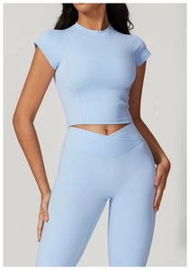 Dettaglio del top corto azzurro a maniche corte e leggings a vita alta con fascia a V