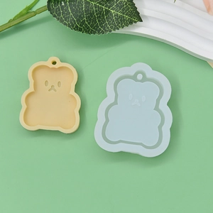 Detail view of a bear-shaped silicone mold and a finished yellow bear cake topper