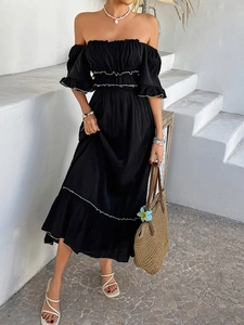 Detail of black off-the-shoulder dress with white ruffle hem and bohemian wavy edges