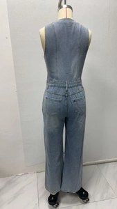 Détail arrière d'une combinaison en jean bleu clair avec larges bretelles et poches plaquées