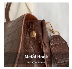 Close-up of brown crocodile texture faux leather and light gold metal hardware hook