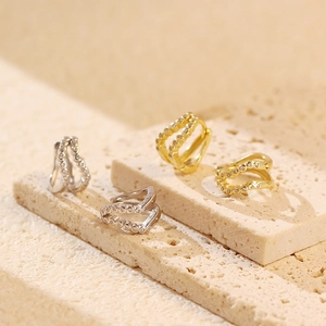 Close-up of gold and silver double-row C-shaped earrings with zircon stones