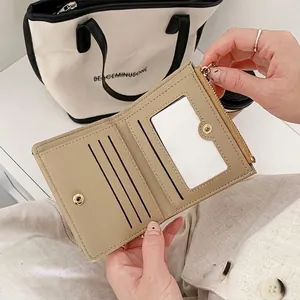 Handheld beige tri-fold leather wallet featuring card slots and gold zipper pocket