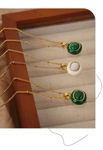 Detailed shot of three gold bead chains with green malachite and white stone pendants