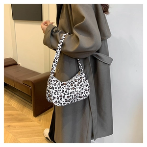 Détail du sac baguette français à motif léopard porté par une femme en trench-coat
