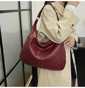 Detailansicht der weinroten Schultertasche aus genarbtem Leder mit Metallschnalle