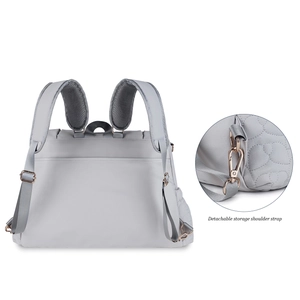 Detail view of the detachable shoulder straps with rose gold buckles on a grey diaper bag