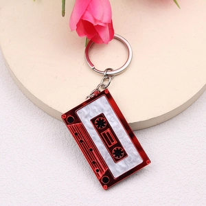 Macro view of a red and marble tape-shaped keychain with engraved FRIEND lettering