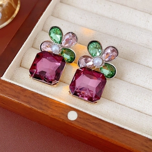 Close-up of vintage flower earrings with colorful crystals and pearls in luxury display
