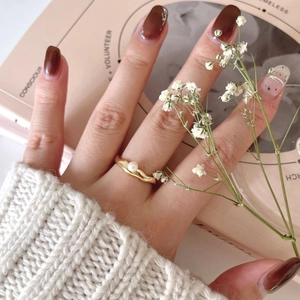 Elegant 925 silver gold-plated ring with a central pearl on a cozy sweater background