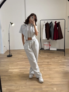 Grey two-piece tracksuit featuring a short zip-up hoodie and high-waisted drawstring joggers