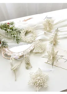 Set of 8 white glittery Christmas ornaments featuring snowflake, star, and bell shapes