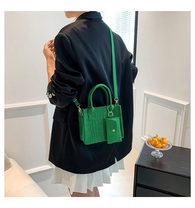 Detail of green crocodile pattern handbag with detachable strap and coin purse
