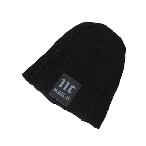 Detail of black knit beanie featuring textured stitching and a custom text fabric label