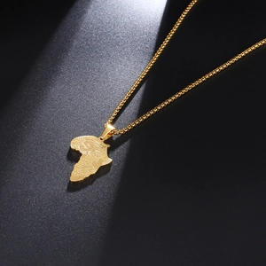 Detail of gold African map pendant with Eye of Horus engraving on textured surface
