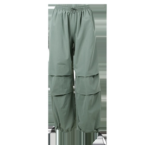 Dettaglio dei pantaloni cargo grigio-verdi con vita elastica e coulisse regolabili