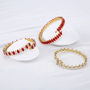 Detailed view of 18K gold-plated bangles with red and white marquise-cut zircon stones