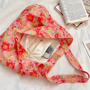 Detail of floral tote bag showing magnetic closure, zip pocket, and beige lining