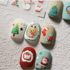 Macro view of 3D embossed Christmas nail stickers featuring Santa and reindeer designs