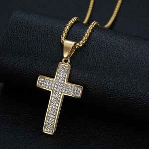 Iced out gold plated cross pendant necklace with full rhinestones on black background