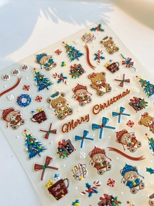 Detailed macro view of 3D embossed Christmas nail stickers with bears and holiday patterns