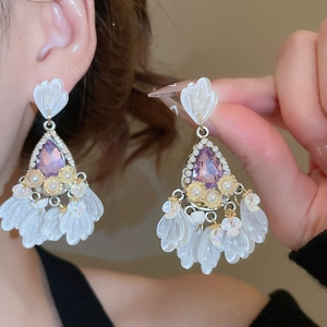 Detail of vintage flower drop earrings with purple crystal and white resin petals