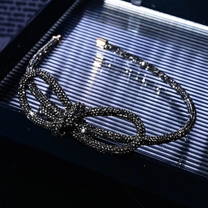 Macro shot of a black rhinestone bow headband with glittering stones and gold end caps