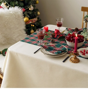 Close-up of beige linen tablecloth set in a festive Christmas dining table scene
