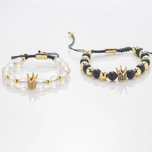 Adjustable couple bracelets with brass crowns and natural stones on reflective white surface