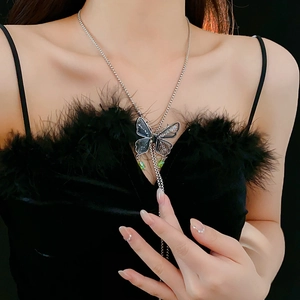 Detail of silver butterfly necklace with crystal tassels and micro-diamonds on dark model