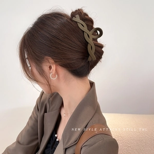 Matte olive green oversized twist hair claw clip shown on a woman from a side-back view