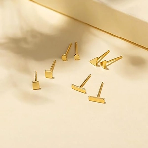 Dettaglio del set di orecchini geometrici dorati con forme tonde e quadrate eleganti