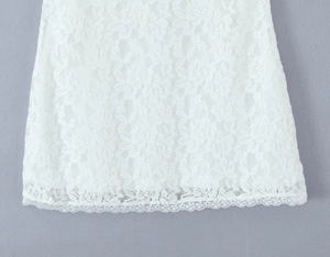 Détail de la dentelle florale blanche avec motifs brodés et bordure festonnée élégante