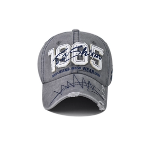 Close-up of 1985 embroidery and vintage distressed details on washed cotton baseball cap