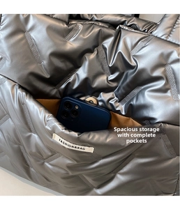 Gros plan du sac cabas matelassé argenté avec poche intérieure marron et espace de rangement