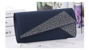 Macro view of navy blue satin evening clutch bag with sparkling silver rhinestone patterns
