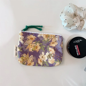 Detail of purple floral cotton pouch with zipper and simple wish woven label