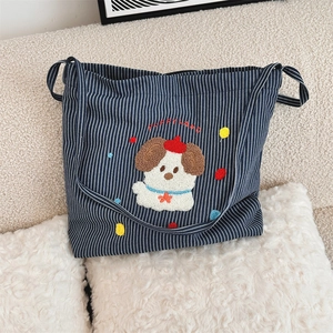 Detail of cartoon puppy embroidery and Puppy Land text on striped canvas tote bag