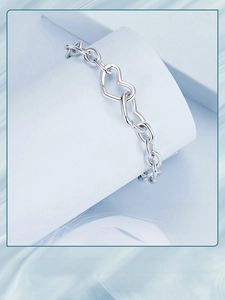 Macro shot of minimalist S925 sterling silver interlocking double hearts clasp bracelet
