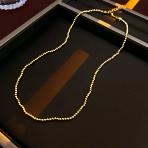 Detail of beaded gold-plated flower pearl necklace with a lobster clasp and extension chain