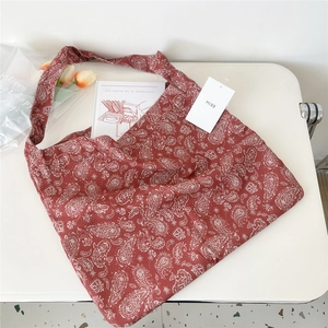 Detail view of large paisley canvas tote bag on white table with tulip decorations