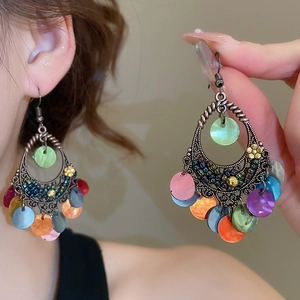 Vue détaillée de boucles d'oreilles bohèmes vintage avec pendentifs en coquillage coloré