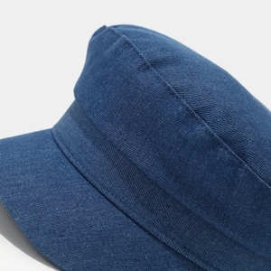 Close-up of high-density navy blue denim fabric and stitching on flat top cadet cap