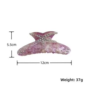 Macro detail of star-shaped hair claw in purple marble acetate with white rhinestones