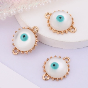 Macro shot of three golden evil eye connectors with white stones for jewelry DIY