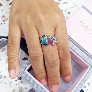 Macro detail of luxury silver ring with colorful emerald-cut zircon and petite diamonds