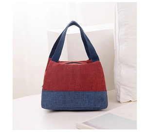 Detail shot of a red and blue color-block oxford fabric lunch bag with top handle and zipper