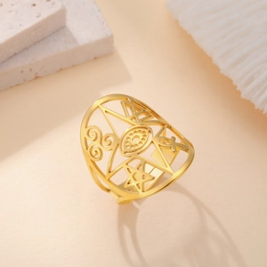 Detail of gold titanium ring featuring hollow carved evil eye and geometric symbols