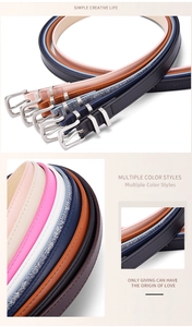 Detail showing various colors of slim leather belts with silver metal needle buckles